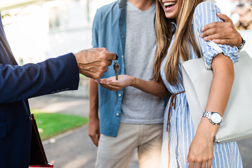 Young happy couple talking with real estate agent